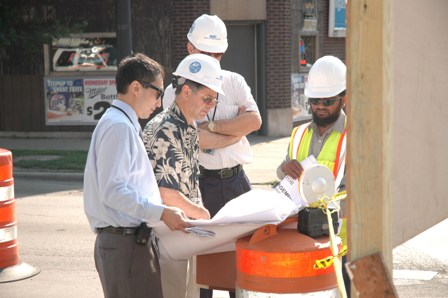 Engineers on the street reviewing sewer plans