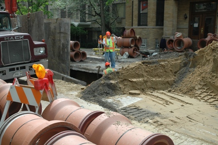Street view of a Department of Water Management crew and equipment in the process of installing a new sewer main.