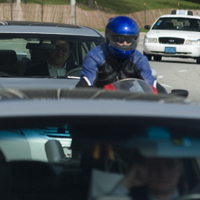 Man on a motorcycle and some cars in traffic